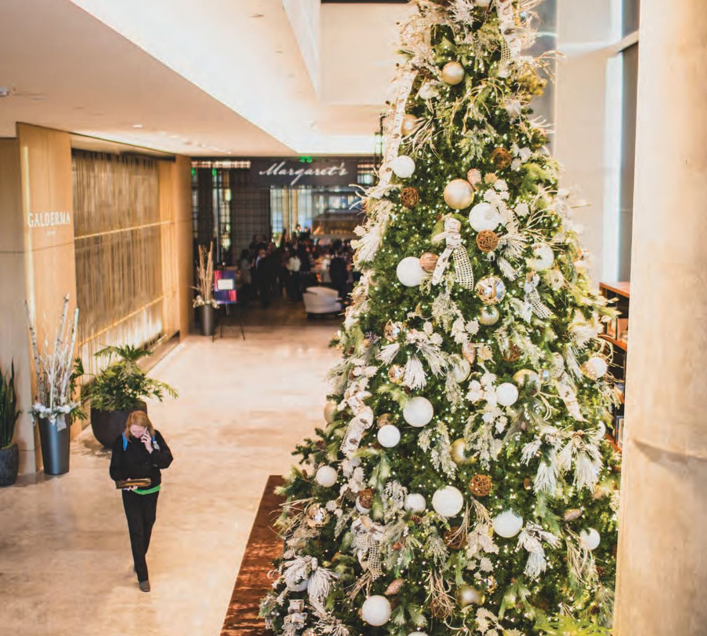 Decorated tree and planters in a hotel lobby corridor